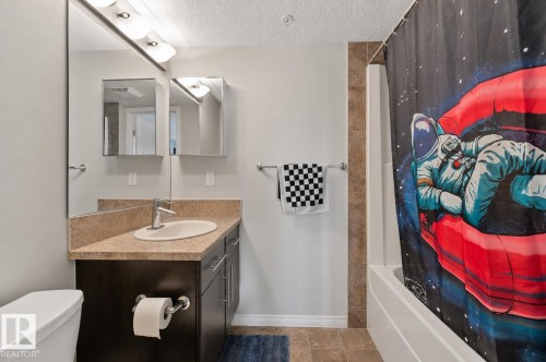 Bathroom featuring a vanity with a light-colored countertop, an oval undermount sink, and a chrome faucet - 206 103 Ambleside Drive, Edmonton, AB - Indoor Photo Showing Bathroom