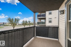 Private balcony featuring a concrete floor, black metal railing, and a privacy screen - 