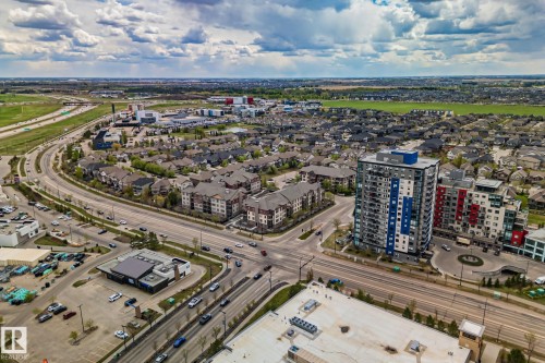 Aerial perspective showcasing a mixed-use neighborhood with residential structures and commercial establishments - 206 103 Ambleside Drive, Edmonton, AB - Outdoor With View