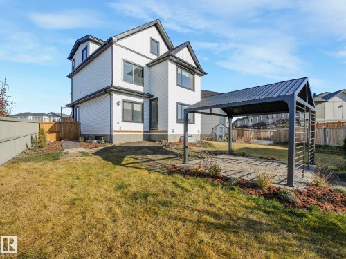 Expansive backyard featuring a built-in pergola with a metal roof, a paved patio area, and a privacy fence - 6613 62 Avenue, Beaumont, AB - Outdoor With Deck Patio Veranda