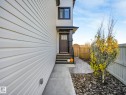 Entryway featuring a dark paneled door, covered porch, and exterior steps with dark risers - 6613 62 Avenue, Beaumont, AB  - Outdoor 