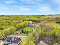 Extensive wooded acreage with a central residence and a second structure featuring a large elevated deck - 