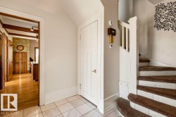 Entryway featuring white tile flooring and a curved staircase with brown carpeted treads - 
