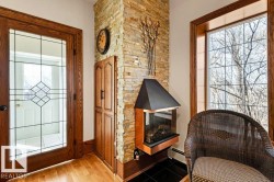Stone accent wall featuring a contemporary fireplace with a black hood and copper base - 