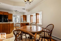 Kitchen featuring wood cabinetry, light-toned countertops, and a black appliance suite - 