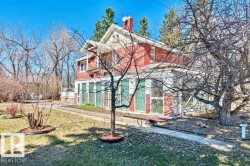 Traditional red brick exterior featuring white trim and a prominent chimney - 