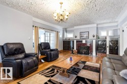 Living room featuring hardwood flooring, a fireplace with a brick surround, decorative sconce lighting, and French doors - 