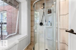 Corner shower with clear glass enclosure and black-finish fixtures - 