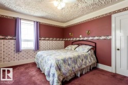 Room featuring a window with natural light, wall-mounted sconces, a textured ceiling, and a paneled door - 
