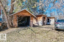 Property features a detached wooden garage with an open bay - 