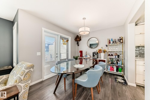 Dining area featuring wood-finish flooring, a contemporary chandelier, and a glass-paneled exterior door - 267 Sturtz Bend, Leduc, AB - Indoor Photo Showing Dining Room