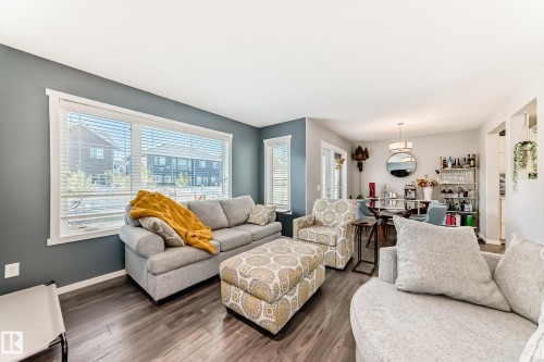 Open-concept living area featuring wide-plank wood-finish flooring, a large picture window, and recessed lighting - 267 Sturtz Bend, Leduc, AB - Indoor Photo Showing Living Room