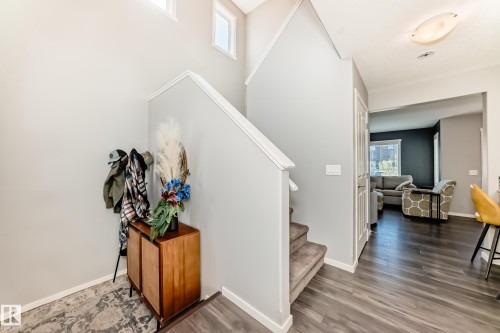 Foyer entry featuring wood-finish flooring and a staircase with carpeted treads - 267 Sturtz Bend, Leduc, AB - Indoor Photo Showing Other Room