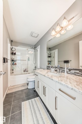 White vanity with brushed nickel pulls, integrated sink, and granite countertop - 267 Sturtz Bend, Leduc, AB - Indoor Photo Showing Bathroom