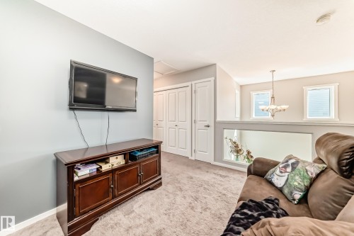 Upper-level landing featuring light gray carpeting and a half-wall overlooking the lower level - 267 Sturtz Bend, Leduc, AB - Indoor