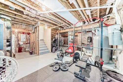 Unfinished basement offering exposed ceiling joists and framing, a partial staircase, and a utility area with visible systems - 267 Sturtz Bend, Leduc, AB - Indoor Photo Showing Basement