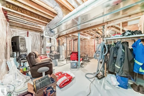 Unfinished basement featuring exposed wood joists, structural support beams, visible ductwork, and insulated walls - 267 Sturtz Bend, Leduc, AB - Indoor Photo Showing Basement