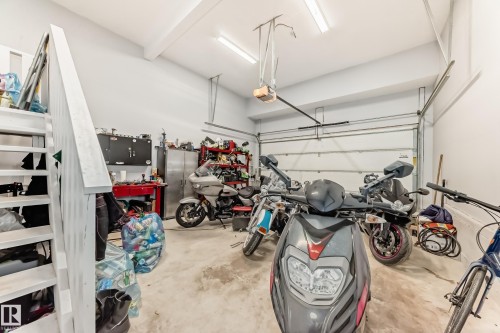 Spacious garage featuring a concrete floor, overhead lighting, and an automatic garage door - 267 Sturtz Bend, Leduc, AB - Indoor Photo Showing Garage