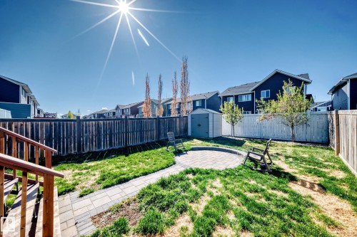 Expansive fenced backyard featuring a paver patio, a paver pathway, and a storage shed - 267 Sturtz Bend, Leduc, AB - Outdoor