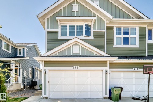 Green siding exterior with white trim accents and a two-car garage - 267 Sturtz Bend, Leduc, AB - Outdoor