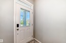 Entry door with a grid-patterned glass insert, a transom window, and a smart lock - 267 Sturtz Bend, Leduc, AB  - Indoor Photo Showing Other Room 