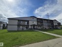 Multi-level residential building featuring exterior siding, private balconies, ground-level patios, and a contemporary architectural style - A7 2808 116 Street, Edmonton, AB  - Outdoor With Balcony With Facade 