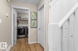 Dedicated laundry area featuring a washer and dryer, wire shelving, and wood-finish flooring - 