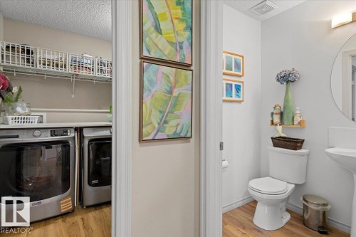 Laundry room featuring wood-finish flooring, white wire shelving, and a countertop - 3356 25 Ave, Edmonton, AB - Indoor Photo Showing Laundry Room