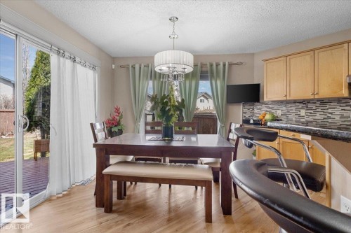 Dining area featuring wood-finish flooring and a contemporary drum pendant light fixture - 3356 25 Ave, Edmonton, AB - Indoor Photo Showing Dining Room