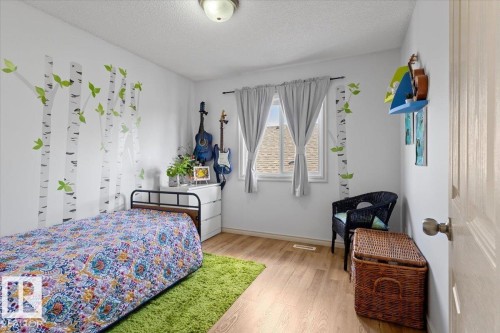 Bright interior space featuring light wood-finish flooring, white walls, and a ceiling-mounted light fixture - 3356 25 Ave, Edmonton, AB - Indoor Photo Showing Bedroom