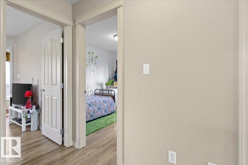 Hallway with light beige wall paint, white trim, and wood-finish flooring - 3356 25 Ave, Edmonton, AB - Indoor Photo Showing Other Room