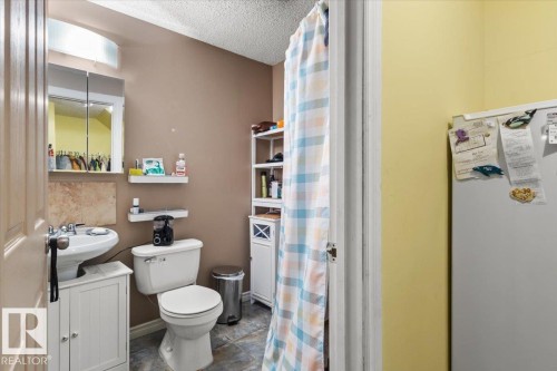 Pedestal sink with white vanity base, toilet, and tiled flooring - 3356 25 Ave, Edmonton, AB - Indoor Photo Showing Bathroom