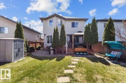 Manicured lawn with stepping stones leading to a spacious elevated deck featuring a gazebo - 
