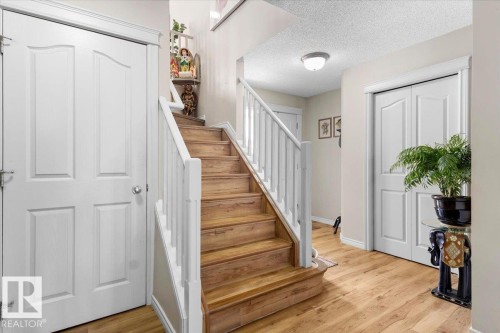Staircase with wood-finish treads and white risers - 3356 25 Ave, Edmonton, AB - Indoor Photo Showing Other Room