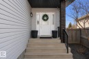 Inviting front entry featuring a white door with sidelights, a dark brick pillar, a black handrail, and concrete steps - 112 Lakeland Point(E), Beaumont, AB  - Outdoor With Exterior 