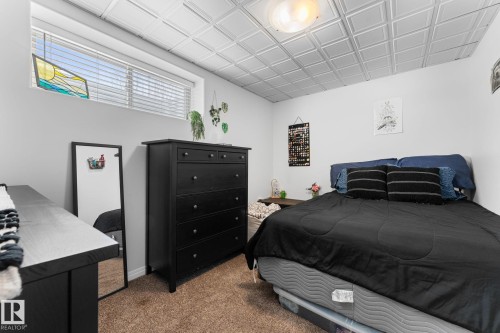 Room featuring textured ceiling panels, a window with blinds, and brown carpet - 112 Lakeland Point(E), Beaumont, AB - Indoor Photo Showing Bedroom
