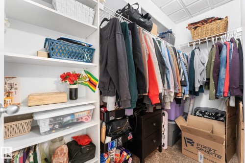 Spacious closet featuring white wire shelving, built-in white shelving units, and a textured ceiling - 112 Lakeland Point(E), Beaumont, AB - Indoor With Storage