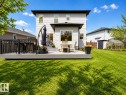 Spacious rear yard featuring a large composite deck with black railings, a dedicated dining area, a storage shed, and a greenhouse - 112 Lakeland Point(E), Beaumont, AB  - Outdoor With Deck Patio Veranda 