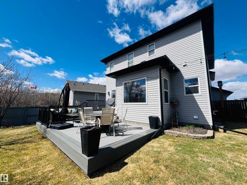 Spacious composite deck with dark railings and a rock-lined garden bed - 112 Lakeland Point(E), Beaumont, AB - Outdoor With Deck Patio Veranda