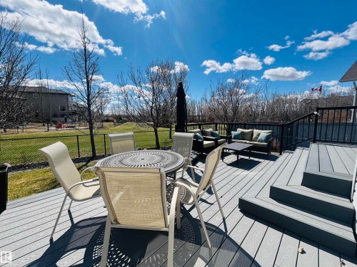 Spacious grey composite deck featuring black metal railings and multi-level steps - 112 Lakeland Point(E), Beaumont, AB - Outdoor With Deck Patio Veranda