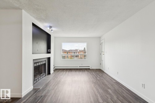 411 9010 106 Avenue, Edmonton, AB - Indoor Photo Showing Living Room With Fireplace