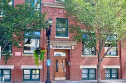 Red brick facade with contrasting light-colored sills, large windows with dark frames, and a prominent "COBOGO LOFTS" sign - 