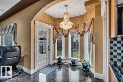 Bay window area with polished dark tile flooring and a multi-tiered crystal chandelier - 