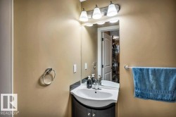 Bathroom vanity featuring a white sink basin, dark countertop, and base cabinetry with knob hardware - 
