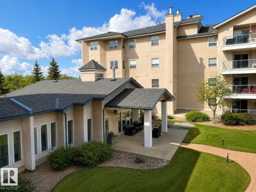 Manicured grounds featuring a brick-paved walking path and a covered outdoor patio - 219 9535 176 Street, Edmonton, AB - Outdoor
