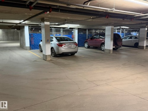 Underground parking space with concrete flooring and pillars - 219 9535 176 Street, Edmonton, AB - Indoor Photo Showing Garage