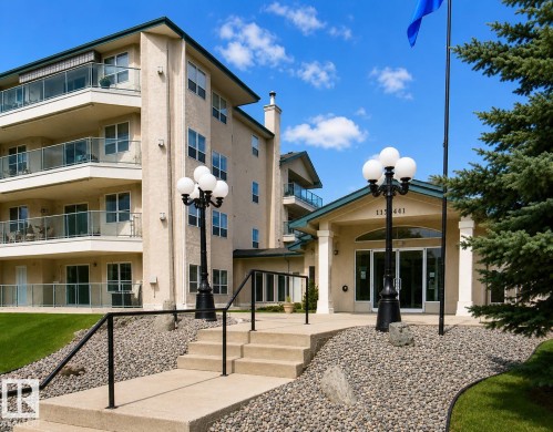 Multi-story building featuring a stucco exterior with multiple balconies, glass railings, and an entry canopy - 219 9535 176 Street, Edmonton, AB - Outdoor