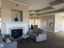 Fireplace featuring a classic white mantel, tile surround, and an integrated niche - 219 9535 176 Street, Edmonton, AB  - Indoor Photo Showing Living Room With Fireplace 