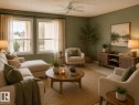 Living area featuring light green walls, a ceiling fan, and two large windows with white trim - 219 9535 176 Street, Edmonton, AB  - Indoor Photo Showing Living Room 