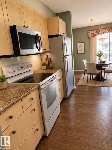 Kitchen featuring light wood cabinetry with bronze hardware, a white electric range, a stainless steel over-the-range microwave, and granite-finish countertops - 219 9535 176 Street, Edmonton, AB - Indoor Photo Showing Kitchen